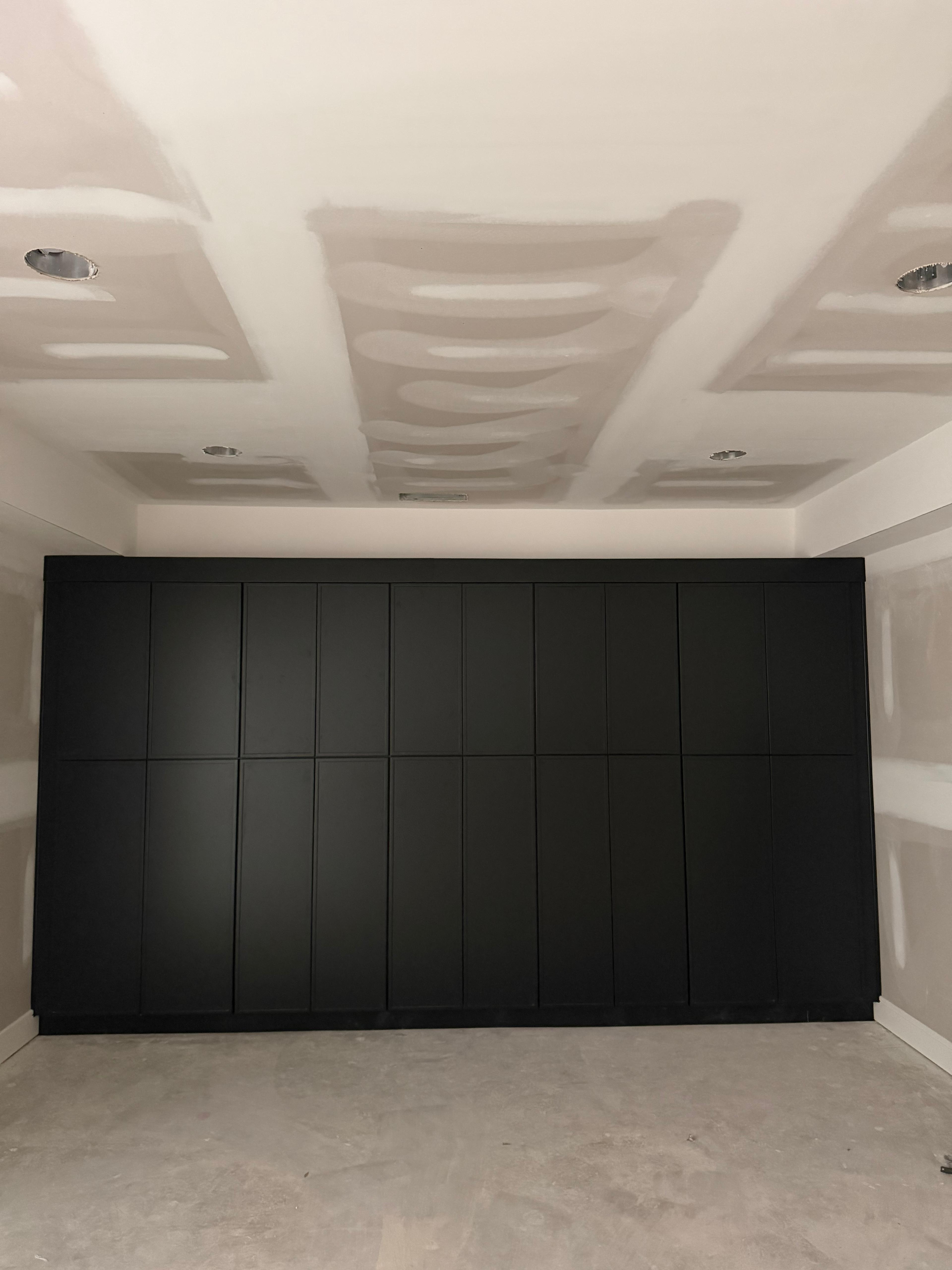 Dark built-in cabinetry during renovation, before the surrounding room is finished.
